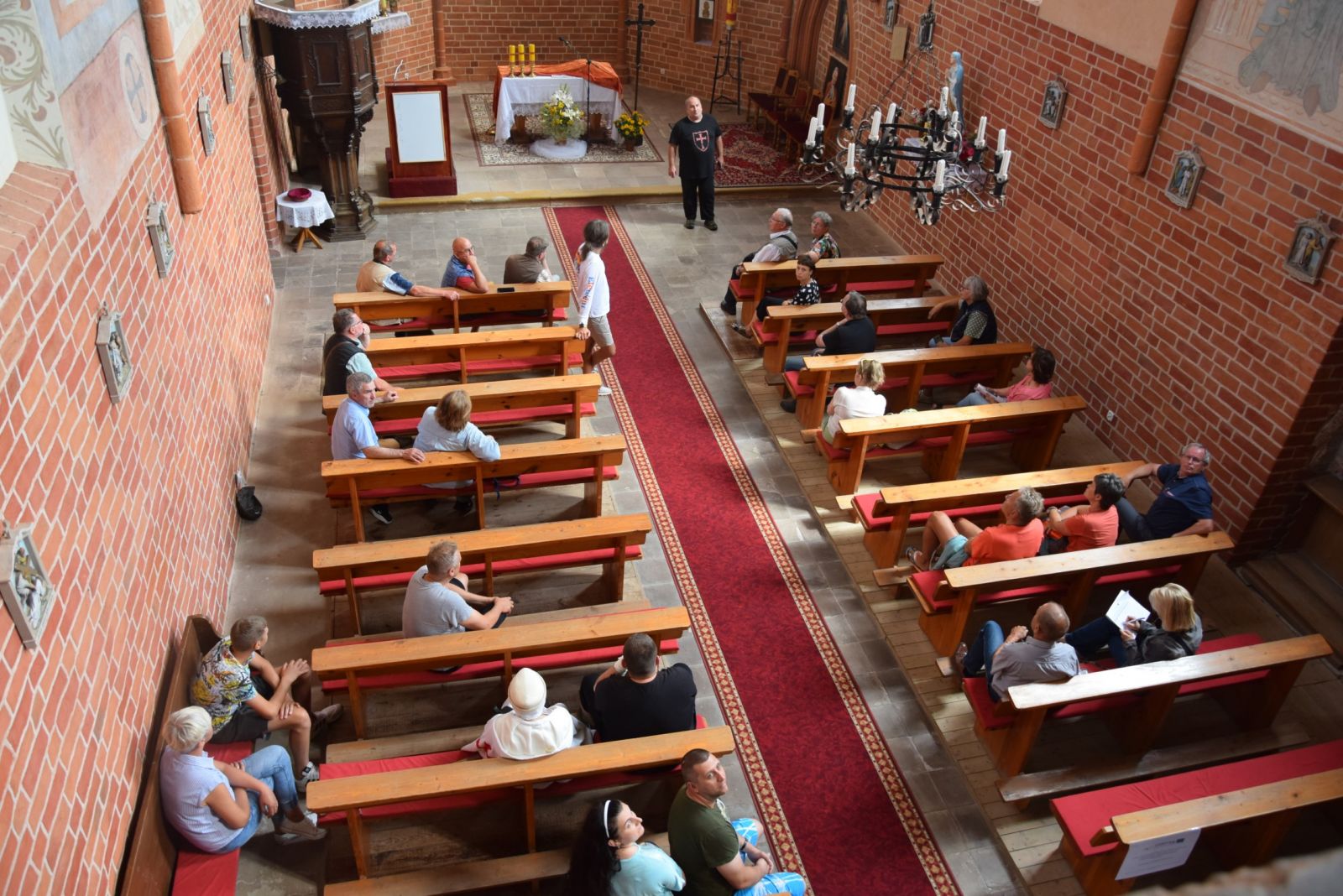 Powiększ zdjęcie. Uczestnicy we wnątrz kaplicy siedzą w ławkach