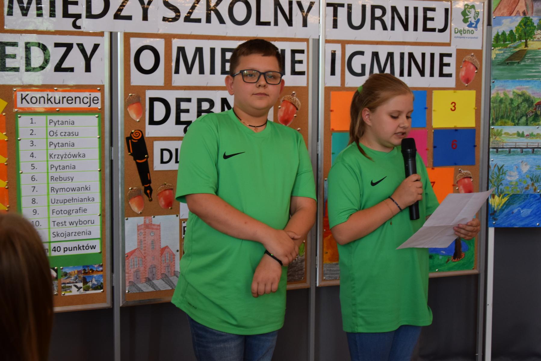 Uczeń i uczennica z SP Różańsko stoją. Dziewczynka trzyma mikrofon i zyta wierszyk