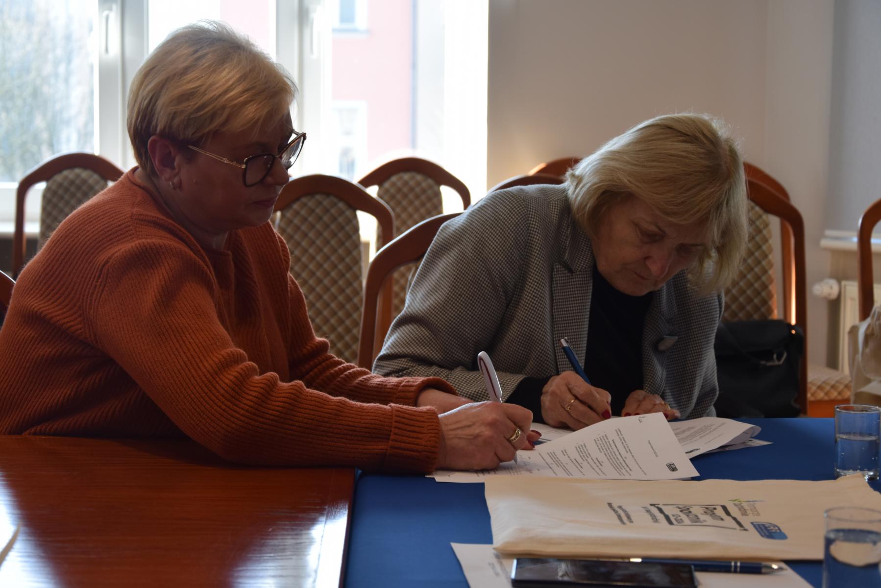 Joanna Ryżyńska i Aniela Kołodziej ze Stowarzyszenia Miłośników Dębna podpisują umowę